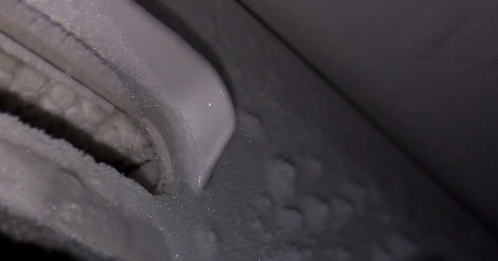 Thick frost covering the air vents inside a freezer
