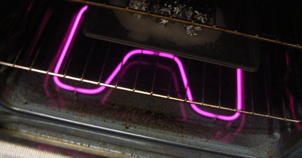 Electric oven bake element glowing under the oven rack during preheat