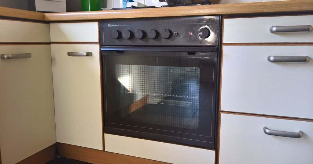 Built-in kitchen oven with its glass door closed, below the cooktop