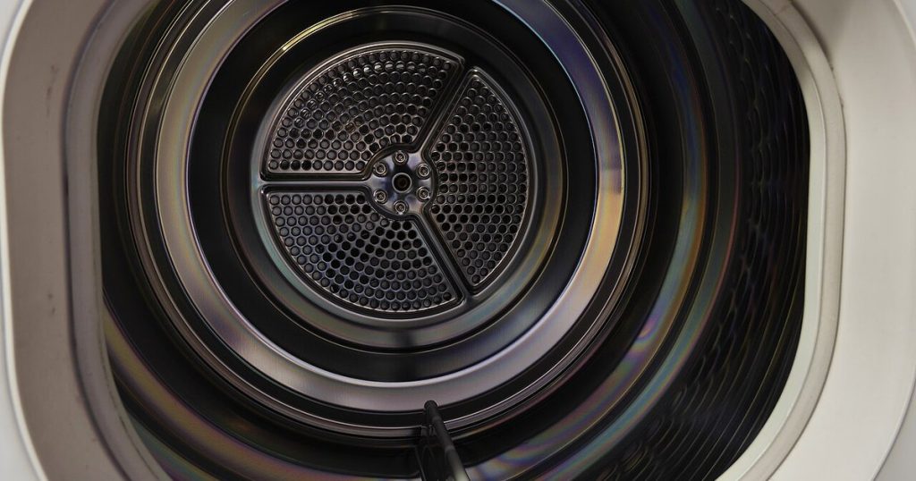 Inside the drum of a front-load clothes dryer, looking toward the perforated back wall
