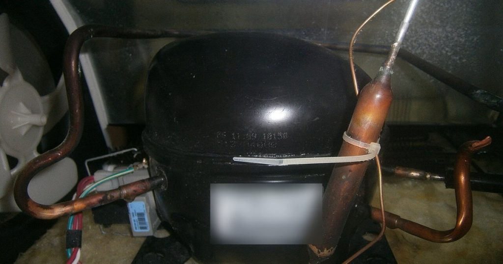 Refrigerator compressor, start relay and condenser fan in the machine compartment of a top-freezer fridge