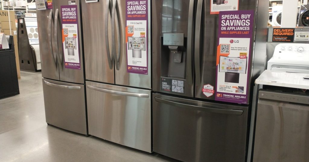 Stainless steel French door refrigerators lined up on an appliance store floor