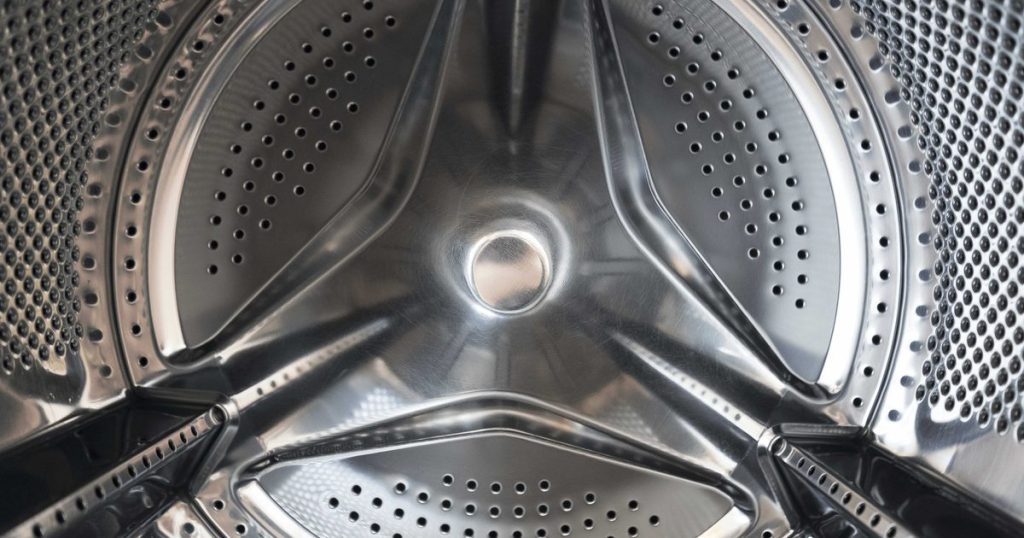 Inside the empty stainless steel drum of a front-load washing machine